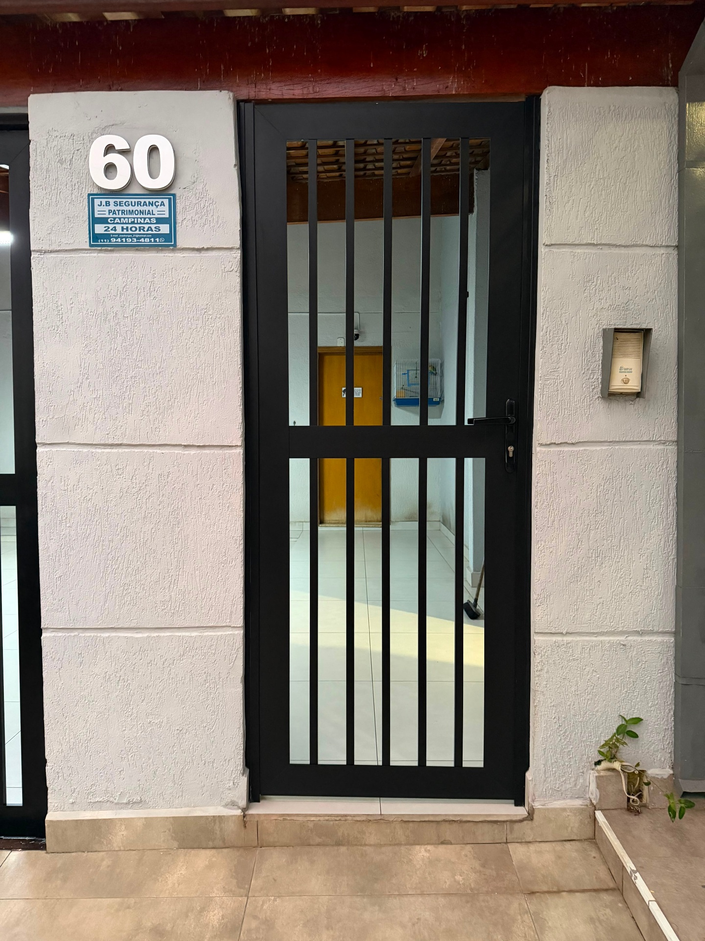 Porta social de alumínio preto com ripado vertical e fechadura — projeto próprio em Campinas